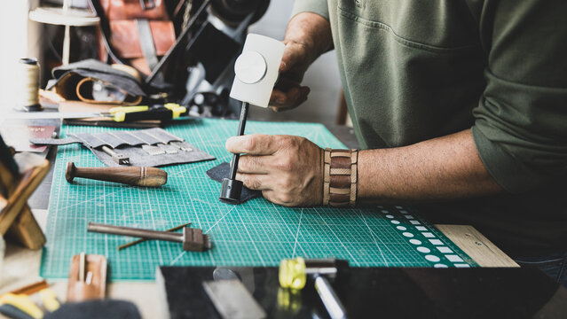 Artisan Hands Cutting Leather with Ruler and Knife