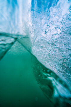 View of a breaking ocean wave with turquoise water and white foam bubbles in the United Kingdom.