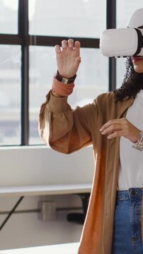 Vertical video: Headset starting, woman in tan top using UI in office testing with watch
