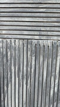 Close up abstract background texture of natural andesite stone cladding with alternating horizontal and vertical slotted lines patterns 