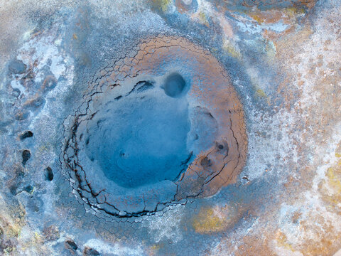 View of Hverir geothermal mud pot with bubbling blue mud, cracked earth, and sulfur deposits in Reykjahlid, Thingeyjarsveit, Iceland.