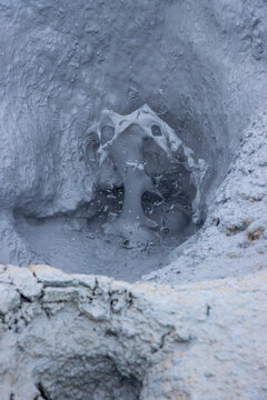 View of bubbling gray mud in a geothermal mud pot at Hverir Sulfur Springs, Reykjahlid, Thingeyjarsveit, Iceland.