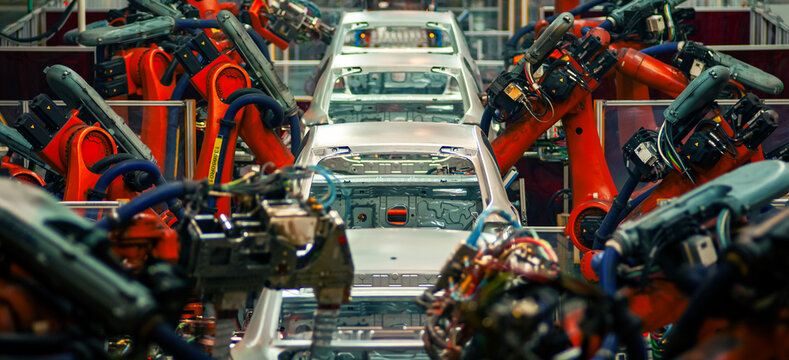 Automated robotic arms working on car body in automotive welding factory
