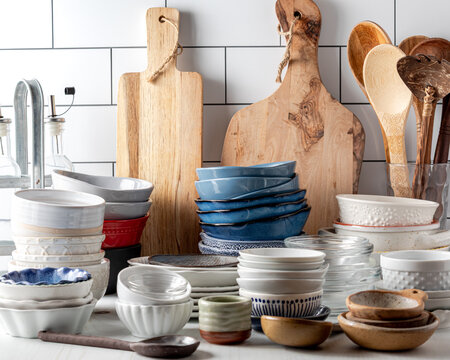 Stacks of various bowls along with wooden cutting boards and spoons.