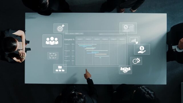 Aerial view of professionals collaborating over a modern, transparent digital interface, showcasing data analytics and business planning tools in a sleek workspace. Raster