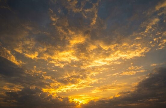 Golden sunlight breaks through dramatic clouds, painting the evening sky with brilliant shades of gold and amber.