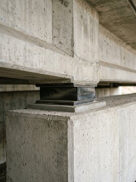 Heavy Duty Elastomeric Bridge Bearing Pad Installed Between Concrete Piers for Seismic Isolation and Structural Support in Modern Civil Engineering Infrastructure Construction Project Detail Close-up