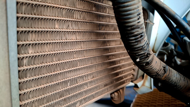 Close up shot of motorcycle radiator mesh fins and rubber coolant hose pipe component.