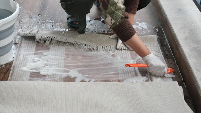 Cleaning a rug with a scrub brush on the floor using soapy water