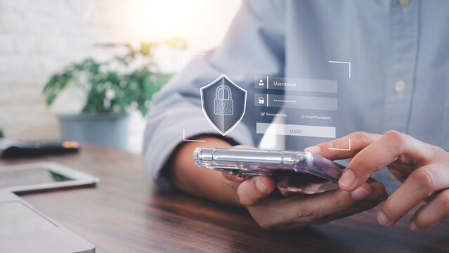 Close up hands using smartphone with digital padlock shield icon and login screen overlay. Concept of cyber security, data protection, privacy, and secure internet access on mobile.