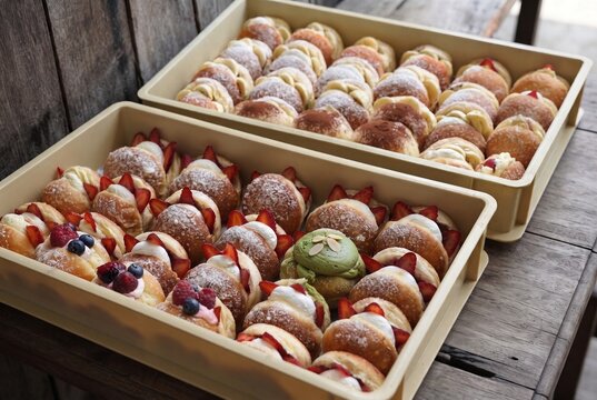 Trays of assorted decorated donuts with colorful toppings