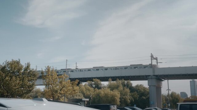 Electric Commuter Train Passing over Railway Bridge Near River in Seoul