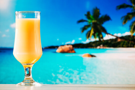Refreshing Tropical Cocktail and Fresh Orange Juice Glasses on a Sunny Beach for Summer Vacation and Seaside Relaxation