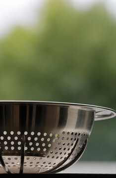 Leeks draining in a colander by a kitchen window