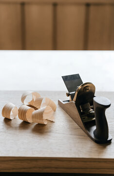 Wood shavings beside a hand plane on a bench