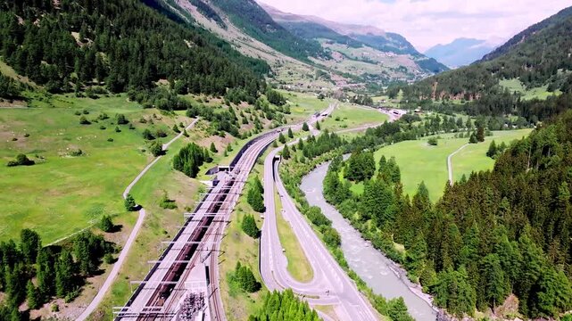 Aerial drone view of the Vereina car transport terminal at Sagliains in the Engadin, featuring railway tracks, loading facilities and the dramatic Alpine landscape of Graub&uuml;nden, Switzerland.