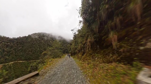Cycling down the North Yungas Death Road in Bolivia surrounded by mountains and fog