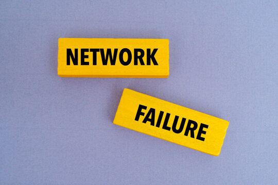 Yellow wooden blocks with text NETWORK FAILURE on purple background. Representing system downtime, connection error, and IT risk
