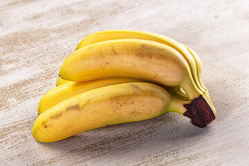 Stone surface yellow banana bunch fruit cluster © Andrei Starostin