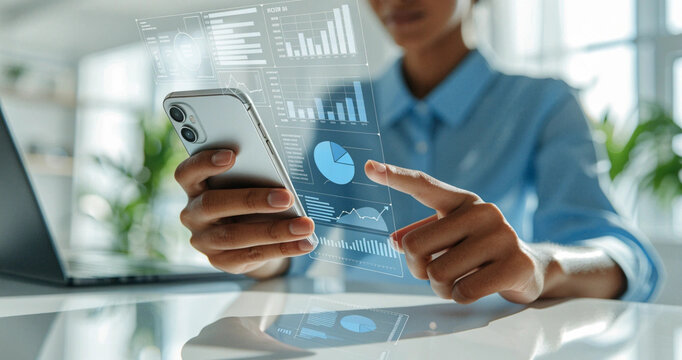 Professional woman touching financial pie chart hologram overlay on smartphone at modern desk. Digital business analytics and market growth chart displayed on smartphone virtual interface screen