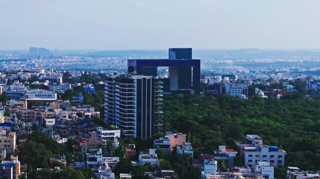 Twin towers of hyderabad city police commissionerate with one hyd park luxury apartments, houses and KBR park at banjara hills, hyderabad, telangana, india. day time, push back shot, drone shot, 4k.