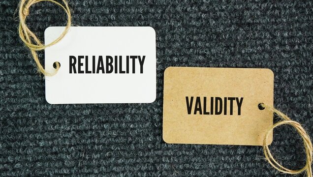 Paper tag with the words reliability and validity. Reliability refers to the consistency of a measure, while validity refers to the accuracy of a measure.