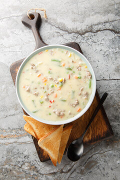 Shepherd's pie soup has all the cozy flavor of classic dish in an easy, creamy soup with beef, vegetables, and potatoes closeup on the plate on the table. Vertical top view from above