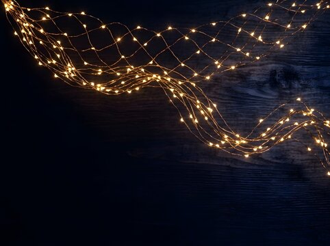Warm golden string lights glow on dark wooden background