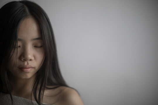 Portrait of a Southeast Asian woman with closed eyes and black hair