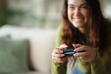 Happy young woman is playing video game using controller © Antonioguillem