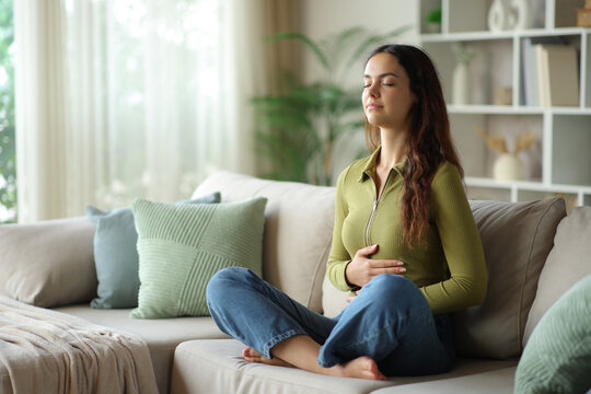 Young woman enjoying good bowel tract sitting on a sofa