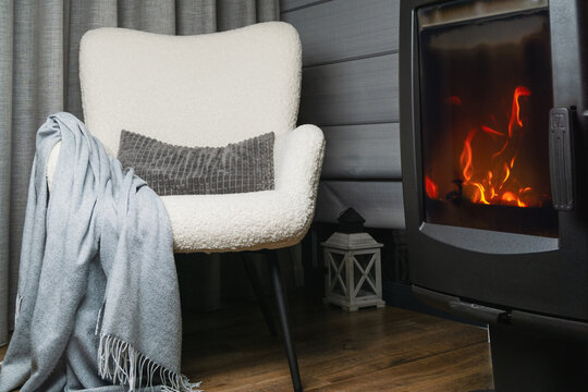 Warmth and comfort found in a cozy chair by a fire in a quiet room