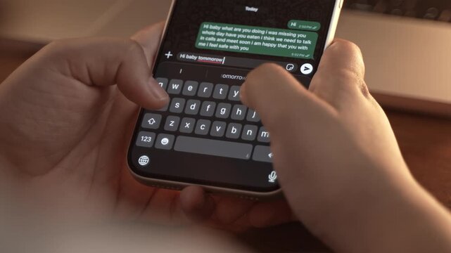 Woman's hand chatting and typing on a smartphone, macro closeup. Unrecognisable human typing a text message, tapping the touchscreen keyboard using the WhatsApp application, a social media.