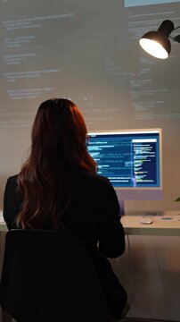 Female software engineer developing code at night