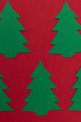 Several paper Christmas trees cut out against a red background, featuring a minimalist design for Christmas greetings, design projects, and promotional materials © Answer 7