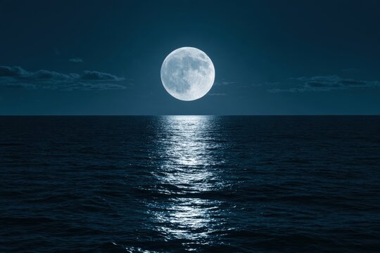 Full moon shining over calm ocean waters at night