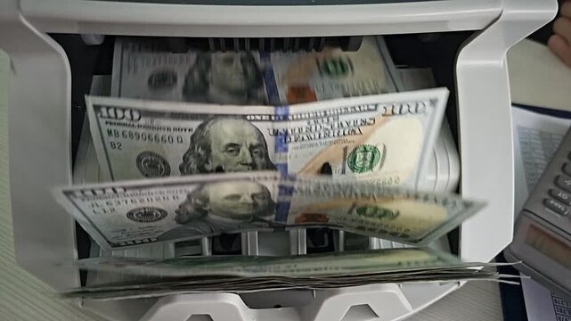 Counted cash being processed in a machine at a financial location