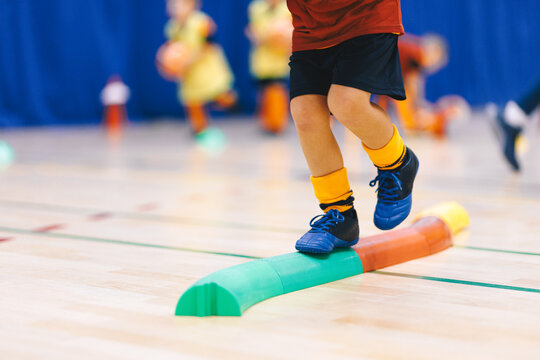 A Young Child Practicing Balance During Physical Education Class, Walking on a Balance Board to Improve Stability, Coordination, and Body Control.