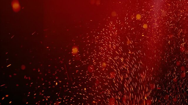 Dramatic video of orange sparks swirling against deep red