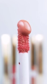 Red liquid flowing downward on a brush. Extreme close up view of brush isolated on white background. Makeup or cosmetic product concept.