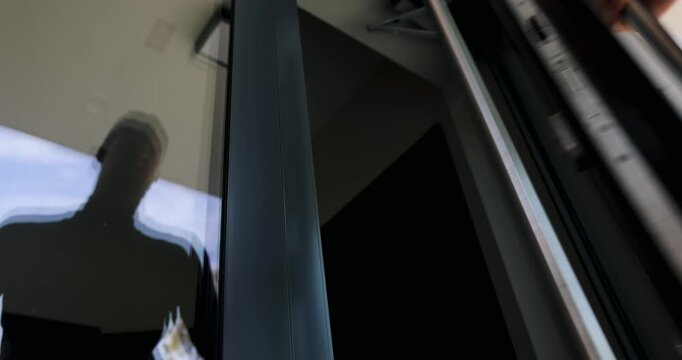 Man opening modern aluminum entrance door with stainless steel handle and enter the building
