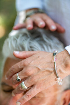 Practitioner positioning hands over the crown and forehead during a spiritual chakra healing session focused on energy balancing, mindful awareness, and deep relaxation.