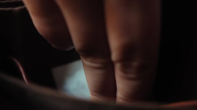 Close up of a hand placing a condom into a bag pocket, illustrating safe sex, contraception and personal protection. High quality 4k footage