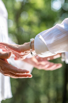 Hands interacting during a chakra balancing practice, symbolizing energetic connection, mindful awareness, spiritual healing, and emotional harmony.