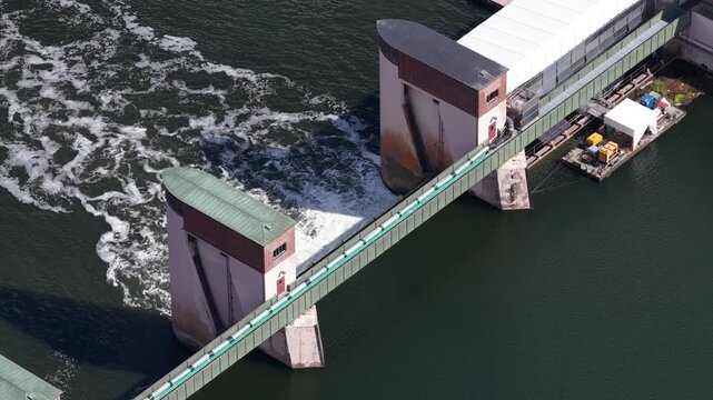 Aerial view of water flowing over river dam weir