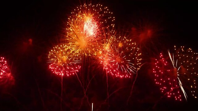Spectacular Golden and Red Fireworks Exploding in the Dark Night Sky for New Year Eve, Festival, and Event Celebration Background   