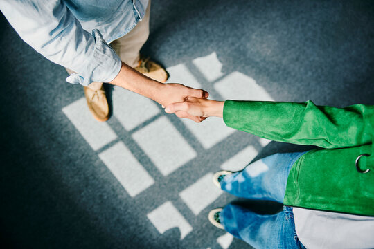 A man and a woman shake hands to seal a business agreement