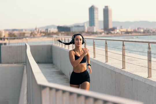 Athletic woman running outdoors in the city for fitness training