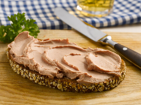 Slice of bread with liverwurst and knife, close-up