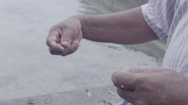 Fisherman Mending Fishing Net with Needle by the Sea, Kei Islands Maluku